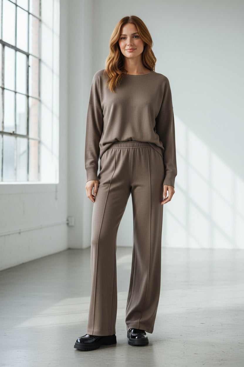 The ELEH - THE SCALA PULL ON SWEATPANT TROUSER by ELEH is a pair of loose-fitting, light brown, velvety pull-on trousers with an elastic waistband, shown against a plain white background.