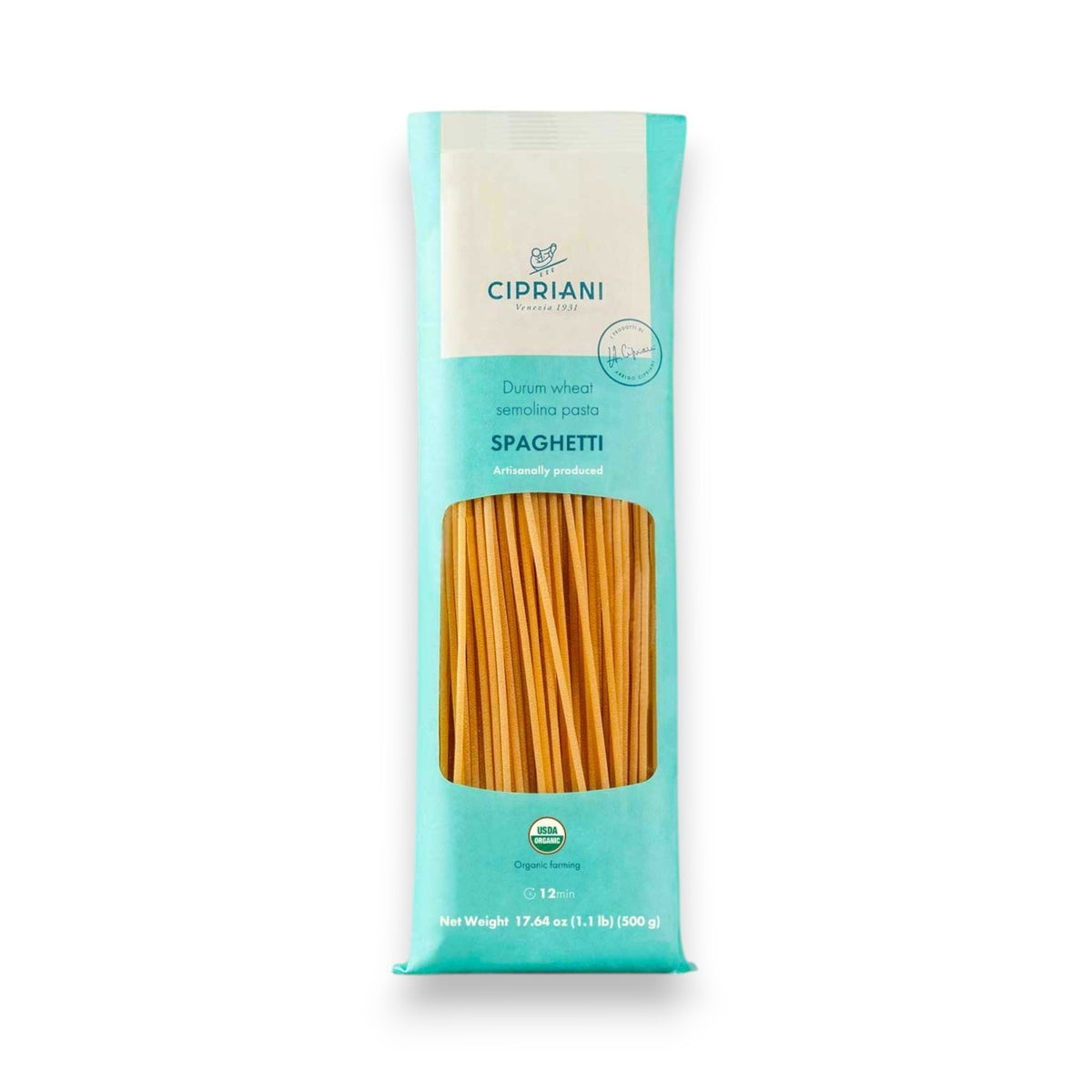 A white oval dish of Atalanta Corporation’s CIPRIANI – ORGANIC SPAGHETTI—made from premium organic durum wheat semolina—is topped with vibrant red tomato sauce and a fresh basil leaf, set atop a white tablecloth and surrounded by plates, cutlery, napkins, and glasses of water.