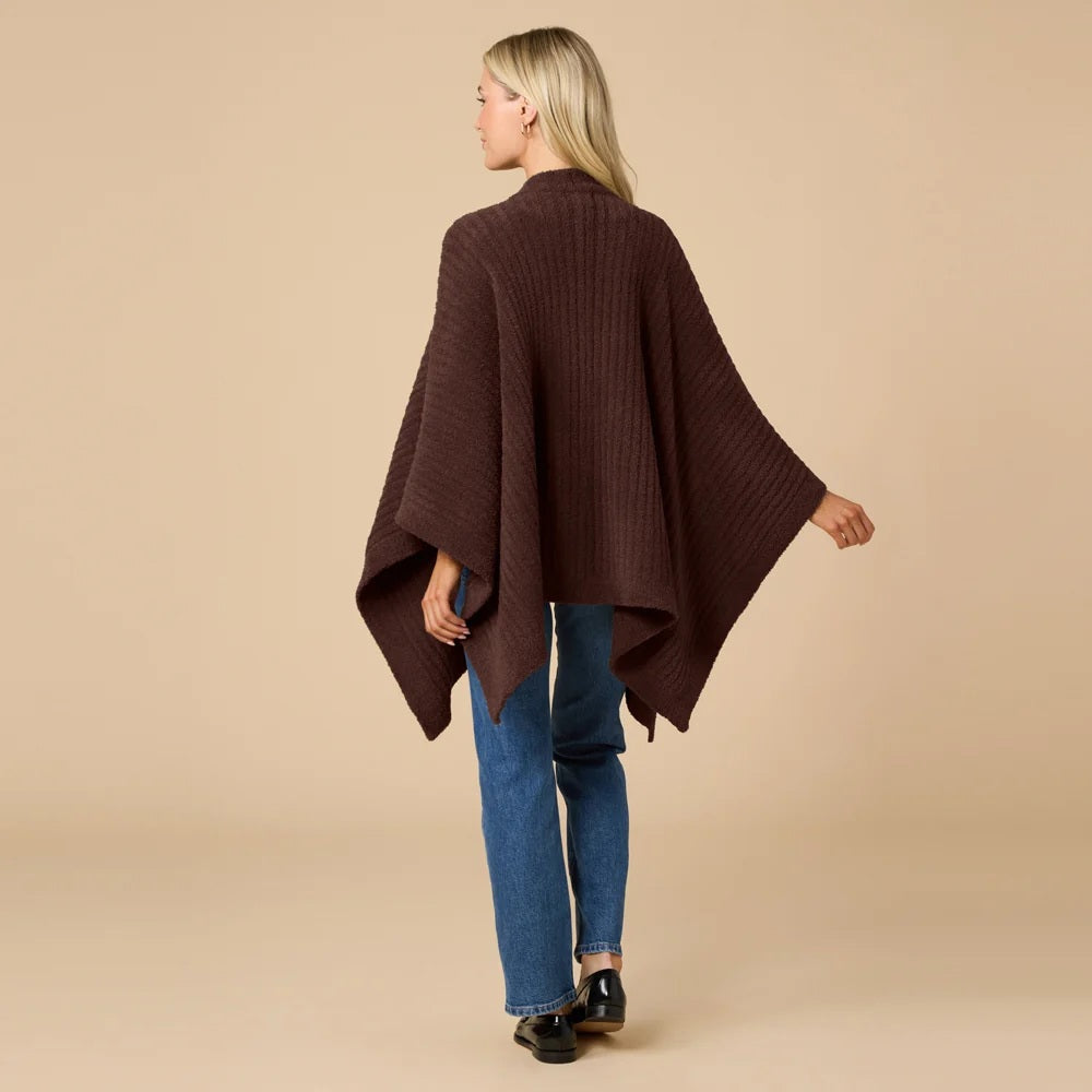 A woman wearing a black SOFTIES - SOLID RIB MARSHMALLOW SHAWL over a grey top and white trousers.