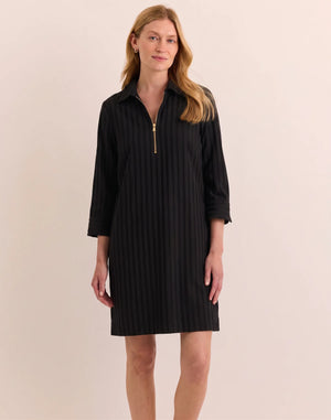 A woman with light brown hair and a slight smile stands against a light background, wearing the HINSON WU - Alessa 3/4 Sleeve Dress in Classic Stripe Black. This knee-length dress features vertical stripes, three-quarter sleeves, and a gold zip-up collar. Crafted from breathable fabric by HINSON WU, the look seamlessly blends style with comfort.