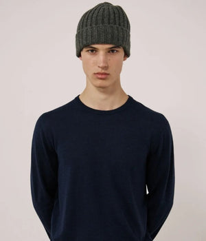 A young person wearing the HARTFORD Cashmere and Wool Beanie in Army looks directly at the camera with a neutral expression, set against a plain white background.
