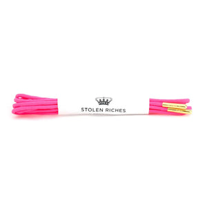 STOLEN RICHES - DRESS SHOELACES IN POONA PINK: Bright pink premium laces with gold aglets, neatly folded and wrapped in a white band labeled "STOLEN RICHES" with a crown logo.