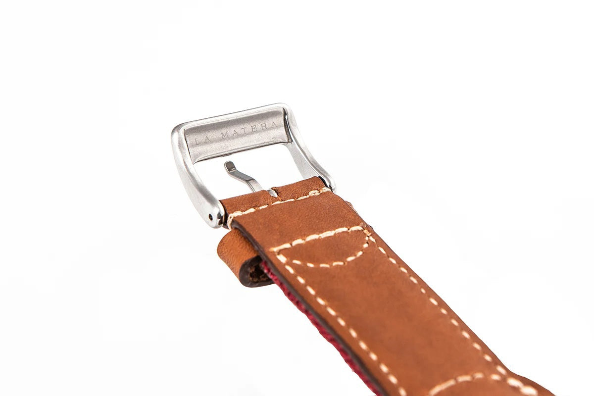 The LA MATERA CORBINA Apple Watch Band in Space Black features a rectangular screen and artisan-crafted brown leather strap with a black woven band adorned with tan diamond patterns, showcasing elegance on a crisp white background.