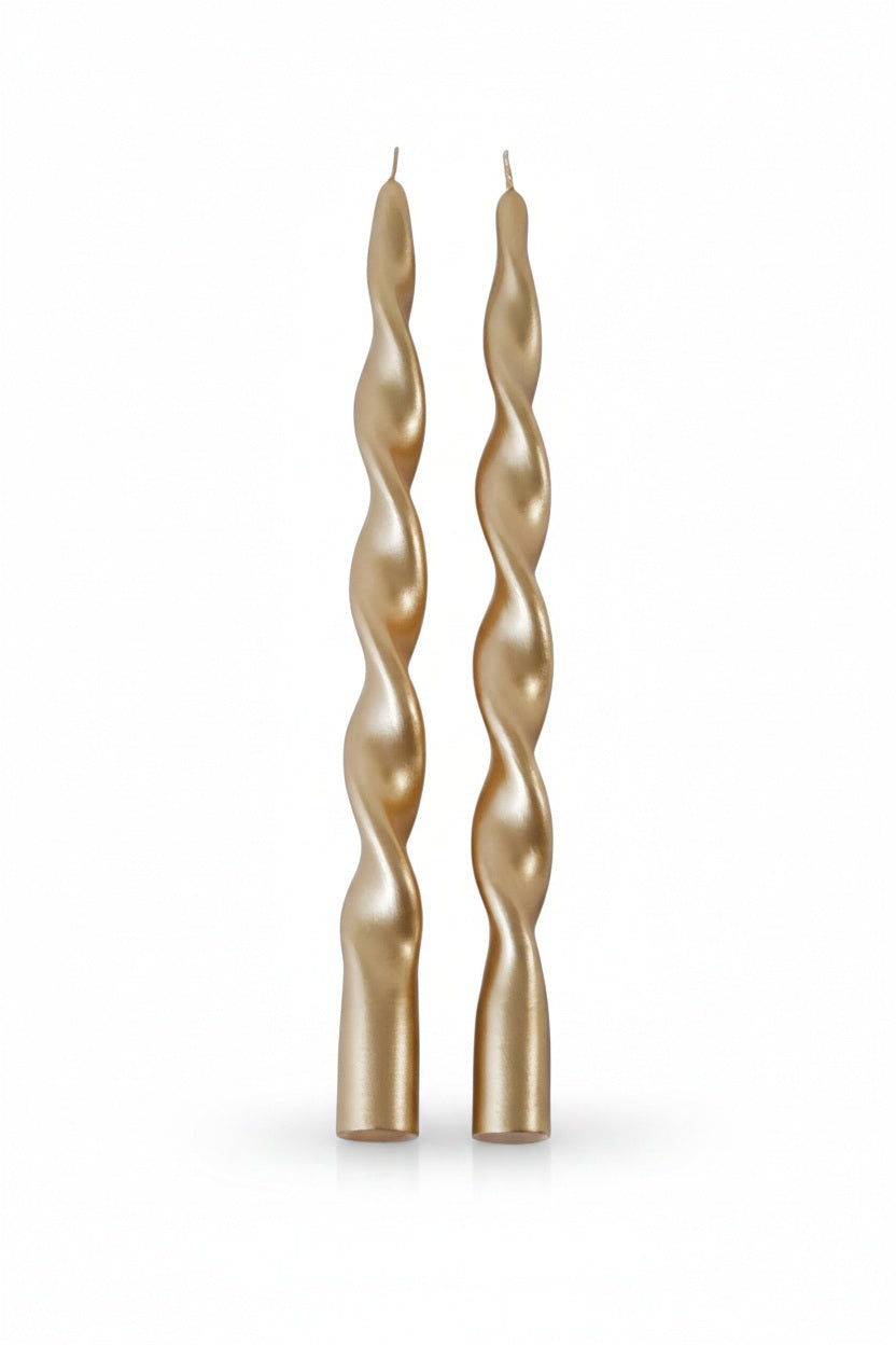 Two gold ZODAX LUMIERE TWIST FORMAL CANDLES made from paraffin wax with a spiral twist design.