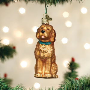 Old World Christmas IRISH DOODLE ORNAMENT, a golden-colored glass dog sitting and wearing a bright blue collar with a small tag.