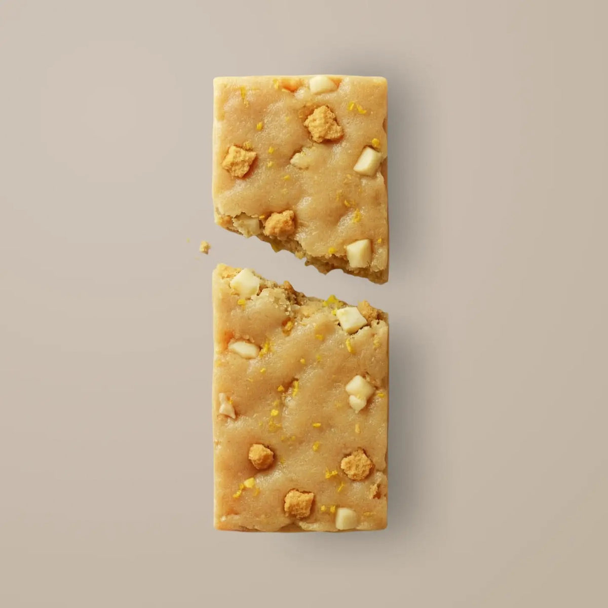 A STARS+HONEY - ICED LEMON COOKIE collagen protein bar in a vibrant yellow wrapper, featuring cookies adorned with white icing and gold sprinkles—some whole, some crumbling—bursting outward against a beige backdrop, capturing a healthy snack from STARS+HONEY packed with delicious flavor.