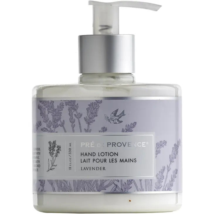 A pump bottle of HERITAGE LOTION - LAVENDER by EUROPEAN SOAPS, LLC. The clear bottle reveals the white, deeply moisturizing lotion enriched with shea butter. The lavender-colored label features images of lavender sprigs and text in English and French. This luxurious, silky-smooth lotion has a capacity of 8.8 ounces (250 ml).