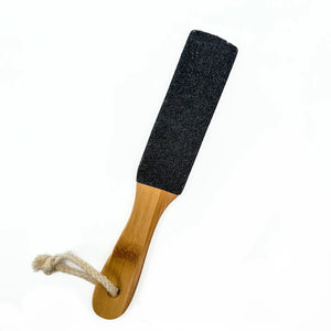 The BAUDELAIRE Bamboo 10" Foot File features a natural pumice surface on one side and a wooden handle with a coarse string loop. Ideal for exfoliating, this product is set against a plain white background.