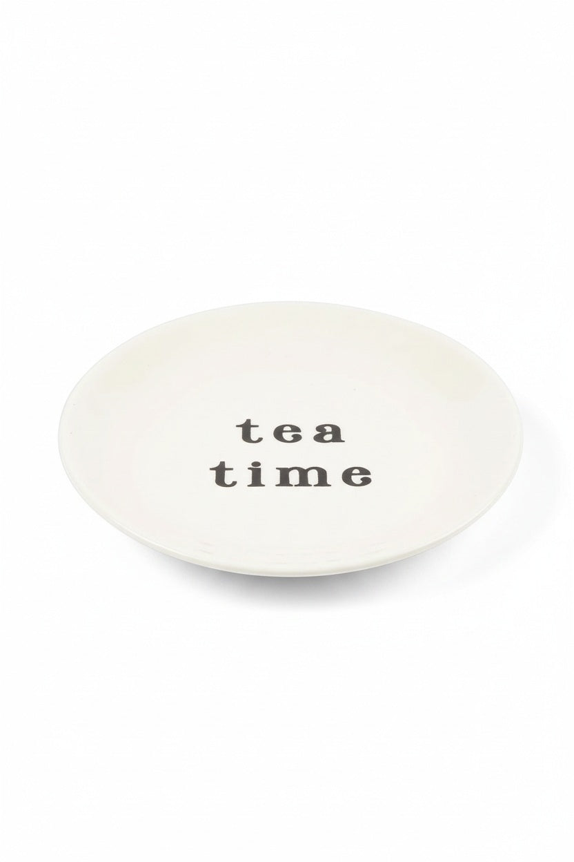 Small, round cream-colored TEA TIME SMALL CERAMIC PLATE with “tea time” printed in black in the center.