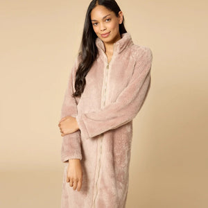 A woman wearing a blush-colored SOFTIES - DREAMPLUSH ZIP ROBE with matching knit socks.