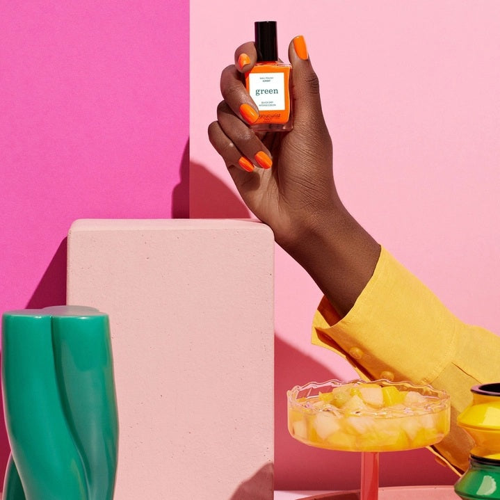 The MANUCURIST - GREEN™ Nail Polish in Sunset by MANUCURIST INC features a vibrant orange hue, packaged with a black cap and a label that says “green, quick dry intense color.” This vegan, non-toxic, and eco-friendly nail polish delivers bold color for your nails.