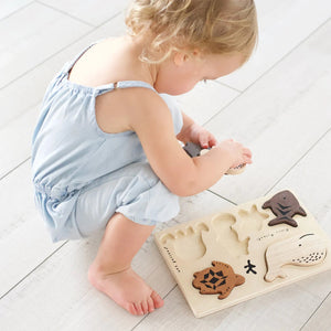The WEE GALLERY - OCEAN ANIMALS TRAY PUZZLE by WEE GALLERY is both an educational and fun set, featuring wooden pieces shaped like a whale, sea turtle, fish, starfish, seahorse, octopus, and coral. Each piece is carefully crafted from wood with simple engraved details to accurately represent each marine creature.