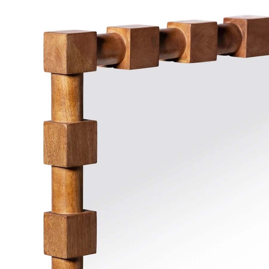 The CADIER MANGO WOOD WALL MIRROR by ZODAX features a rectangular design with a wooden frame adorned with evenly spaced, raised square blocks, shown standing against a plain white background.