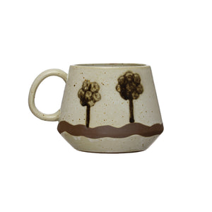 The HAND-PAINTED STONEWARE MUG WITH TREES by CREATIVE COOP features a beige finish, wide base (4.5" width, 3.5" height), round handle, tree design with a wavy stripe—an artisan mug ideal for your favorite coffee or tea.
