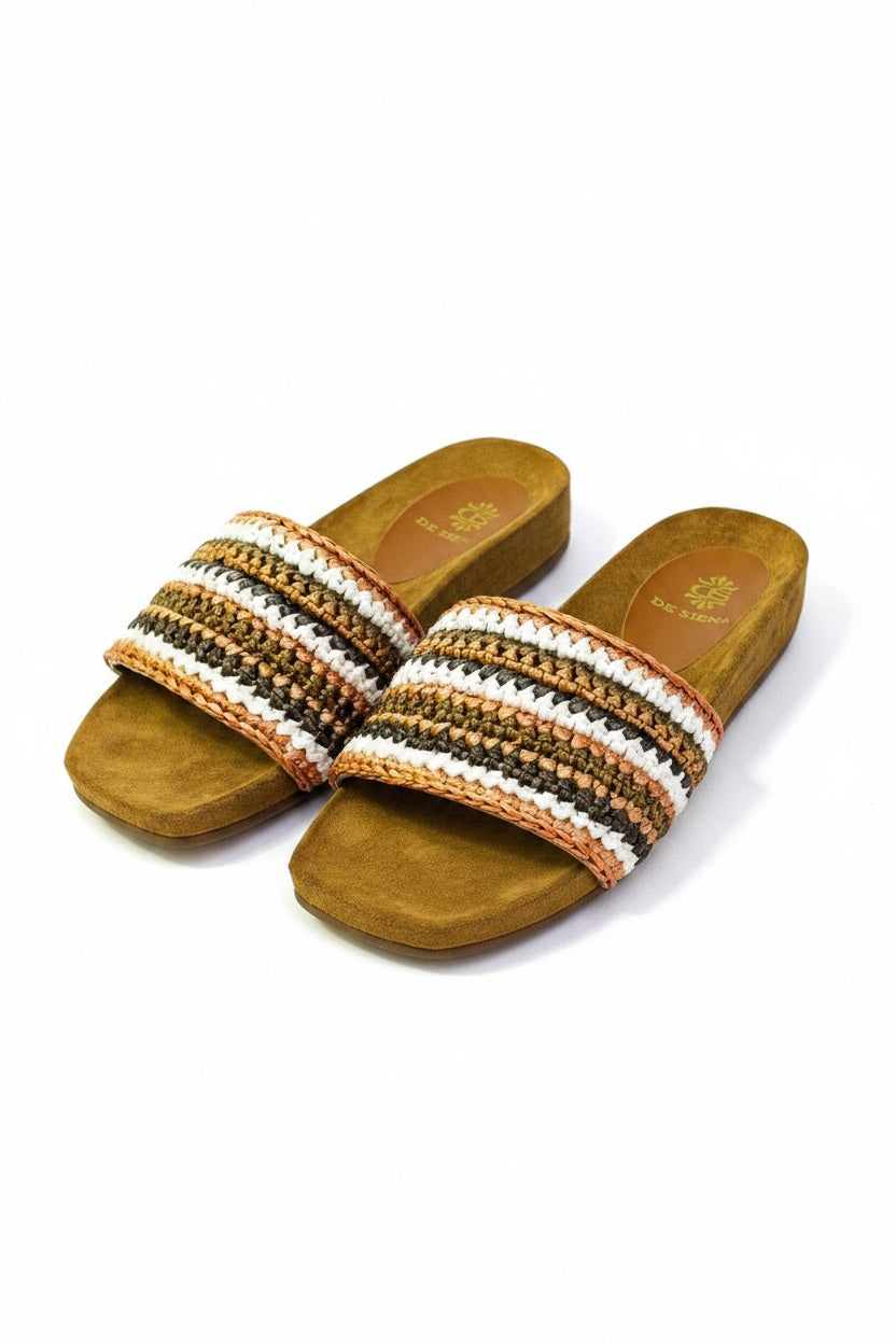The DA SIENA - LUCILLA RAFIA SLIDE by DE SIENA features open-toe sandals with brown suede soles, a comfy eco footbed, wide multicolored woven straps in green, blue, yellow, and brown stripes, and a branded floral "DE SIENA" insole.