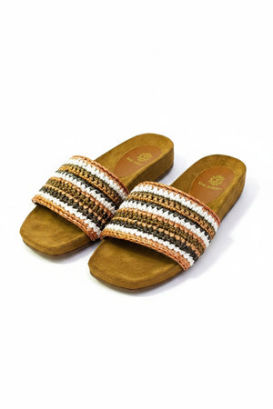 The DA SIENA - LUCILLA RAFIA SLIDE by DE SIENA features open-toe sandals with brown suede soles, a comfy eco footbed, wide multicolored woven straps in green, blue, yellow, and brown stripes, and a branded floral "DE SIENA" insole.