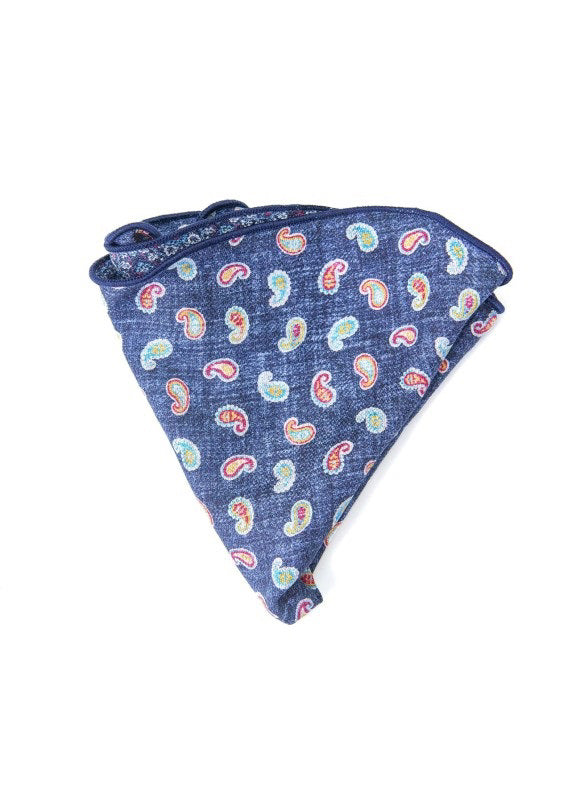 The EDWARD ARMAH Silk Reversible Pocket Circle in Denim Paisley features a floral pattern on one side and a vibrant paisley print on the other, folded to highlight both striking designs.