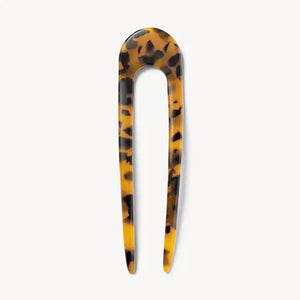 A smooth, black MACHETE - FRENCH HAIR PIN with two prongs, crafted from Italian acetate by MACHETE, rests on a plain white surface.