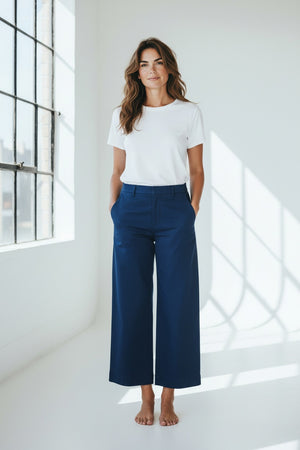 The FRANK & EILEEN Westport Italian Wide-Leg Chino in Navy is elegantly showcased against a plain white background. It features a tailored fit with side pockets and a contour waistband, neatly folded to highlight the crisp, smooth fabric, epitomizing effortless sophistication and style.