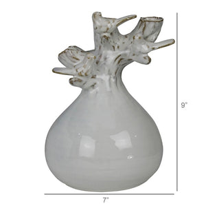 The HOMART CERAMIC VASE WITH BRANCH AND BIRD features white flowers and branches, set on a wooden surface with framed bird art and a woven basket against a light gray textured wall for a cozy touch.