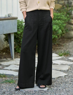 A person wearing the FRANK & EILEEN Madeline Patch Pocket Pull On Pant in Famous Denim Black styled with a beige knit sweater, shown from waist to mid-thigh.
