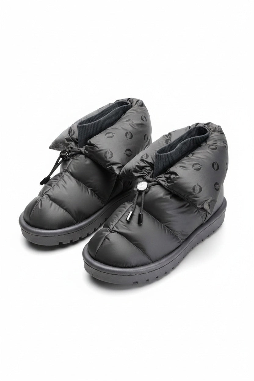 The FLUFIE METALLIC PILLOW BOOT is a pair of gray, insulated slippers with drawstring closures, a high folded collar, water repellent fabric in a subtle circular pattern, designed for warmth and shown on a white background.