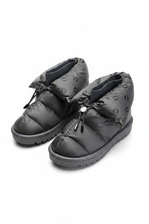The FLUFIE METALLIC PILLOW BOOT is a pair of gray, insulated slippers with drawstring closures, a high folded collar, water repellent fabric in a subtle circular pattern, designed for warmth and shown on a white background.