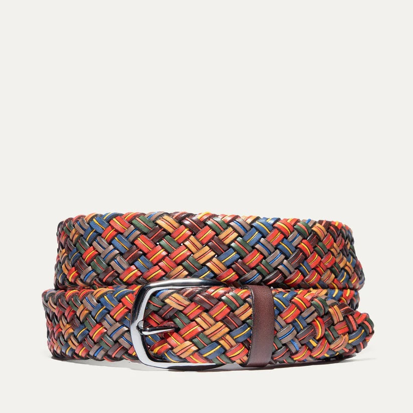 The WILL LEATHER GOODS - TUBULAR BRAIDED BELT IN MULTICOLOR features red, yellow, blue, brown, and orange leather strands with a silver buckle, shown coiled on a plain light background.