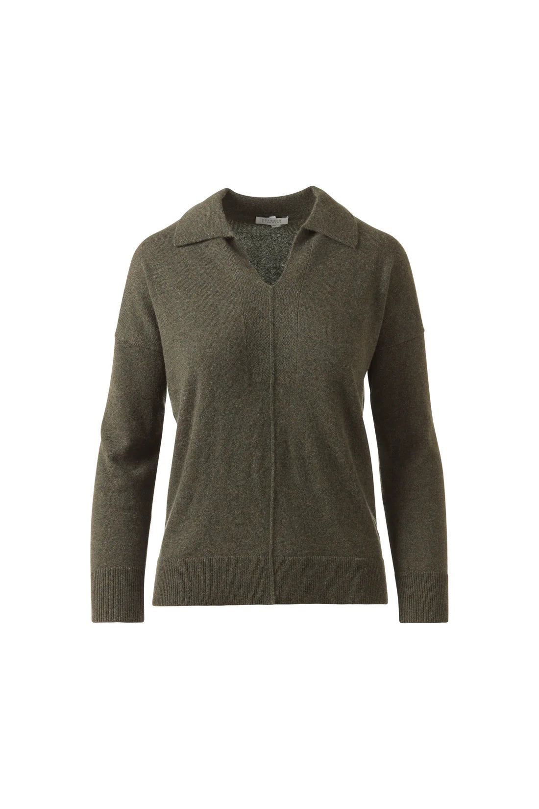 A woman stands against a white background, wearing the KINROSS CASHMERE Splitneck Polo in cashmere. She pairs it with matching pants, poses relaxedly while holding the hem of her top, and smiles softly.