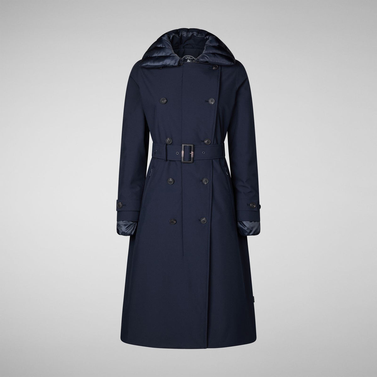 The SAVE THE DUCK GABRIELLE LONG SLEEVE COAT, a navy blue, water-resistant trench with a belted waist, matching buttons, and quilted hood and cuffs from SAVE THE DUCK, is shown on a plain light gray background.