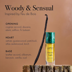 A yellow bottle of LAFCO - FINE FRAGRANCE, FIRESIDE LIGHT 10ML stands upright on a white background, featuring a marble-patterned green cap and reflecting the ambered vanilla notes of this vegan perfume.