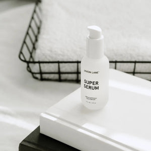 A white bottle labeled "JAXON LANE - SUPER SERUM ULTRA LUMINOUS FACE SERUM FOR MEN," 1 fl oz / 30 ml, with a white cap stands upright on a plain white background—ideal for men seeking a brightening serum with niacinamide.