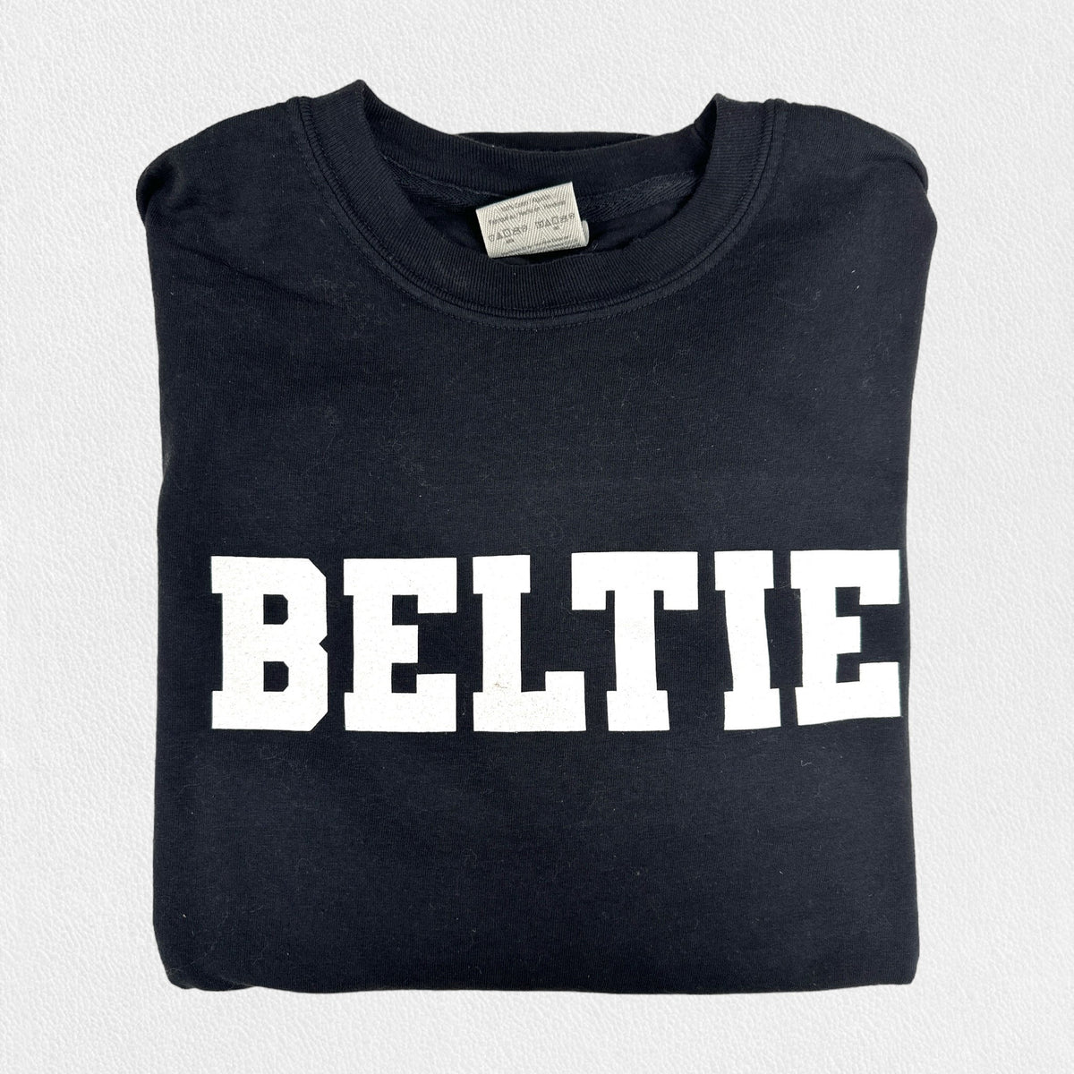 A black, unisex tee with short sleeves and a crew neck from the FEARRINGTON LIFESTYLE COLLECTION - BELTIE SHORT SLEEVE TEE SHIRT by COMFORT COLORS. The word &quot;BELTIF&quot; is printed in bold white capital letters across the chest. Made with premium fabric, this shirt is showcased on a plain light-colored background.