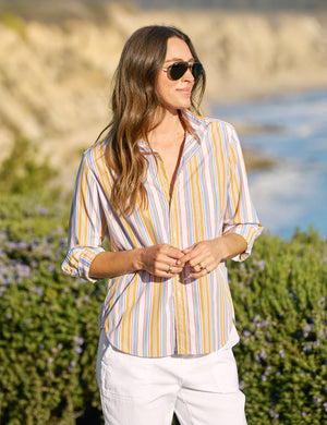 The FRANK & EILEEN EILEEN Relaxed Button Up in Italian cotton stripe features vertical yellow, blue, white, and orange stripes with long sleeves, a left chest pocket, open collar, and rolled-up sleeves for a flattering look.