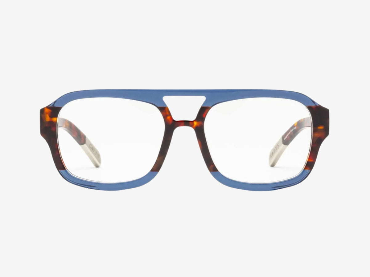 A pair of eyeglasses with a bold, rectangular frame that is blue on the top and tortoiseshell brown on the bottom, featuring clear lenses and wide arms.