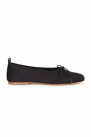 The AUGUSTA - SIENNA BALLET FLAT by AUGUSTA, handcrafted in Spain, showcases a silver finish with a front bow, low brown sole, and heel pull tab, displayed in side profile against a plain light background.