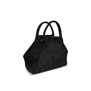 The OLIVEVE Taya Top Handle Crossbody in black Italian leather-backed suede is showcased on a white background. With angular sides, short handles, and a detachable crossbody strap featuring gold clasps, this elegant design blends style and versatility.