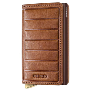 A slim, rectangular SECRID - PREMIUM SLIMWALLET+ EMBOSS LINES IN COGNAC cardholder, displayed vertically with a brown embossed finish and metallic bottom edge. This RFID-protected wallet from SECRID effortlessly combines sophisticated style and security for your daily essentials.