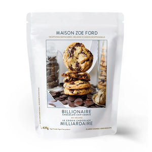 A white pouch of MAISON ZOE FORD BILLIONAIRE CHOCOLATE CHIP COOKIE Mix, showing stacked chocolate cookies with chocolate pieces and baking ingredients, promises an easy, bakery-quality cookie experience from MAISON ZOE FORD.