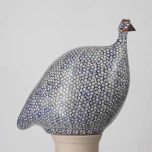 Four matte white, cobalt-spotted ceramic French guinea fowl sculptures from Les Ceramiques de Lussan—labeled Large, Medium, Small, and Pecking—illustrate the available sizes. Above them, the heading reads “AVAILABLE SIZES.” Each handmade piece by LES CERAMIQUES DE LUSSAN captures the charm of guinea fowl in every dimension.