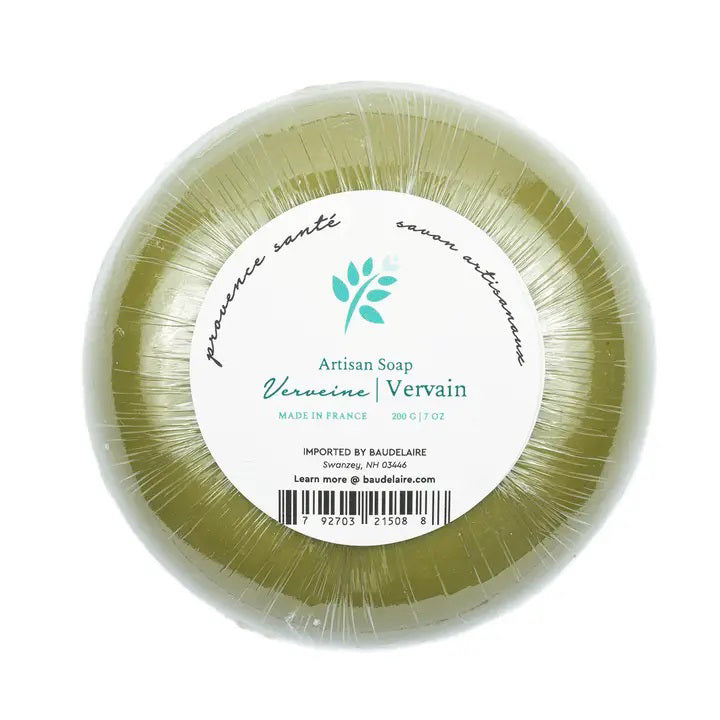 A hexagonal teal-colored box labeled &quot;BAUDELAIRE&quot; at the top. The text reads &quot;Verveine/Vervain savon artisanal - Artisan Soap.&quot; Infused with shea butter and boasting a vervain scent, the design includes light blue abstract shapes resembling flowers and leaves. The bottom text indicates 200 g / 7 oz, Made in France. This product, known as the BAUDELAIRE - VERVAIN 7OZ BOXED BATH BAR, is offered by the brand BAUDELAIRE.

