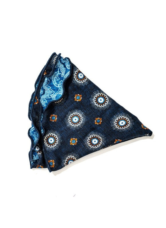 The EDWARD ARMAH Silk Reversible Pocket Circle in Navy Medallion features blue floral and swirl patterns with a dark scalloped edge, shown folded against a white background.