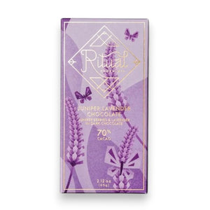 The RITUAL CHOCOLATE - JUNIPER LAVENDER CHOCOLATE bar by RITUAL CHOCOLATE features a purple wrapper with lavender, butterflies, and gold accents. This 70% cacao dark chocolate weighs 2.12 oz (60g) and includes juniper berries and lavender.