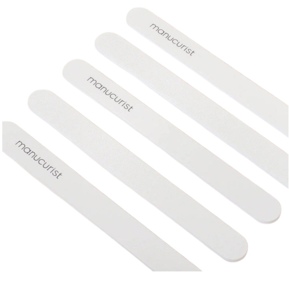 Five MANUCURIST - EMERY BOARD nail files from MANUCURIST INC, each featuring the brand’s logo, are arranged diagonally on a light beige background.