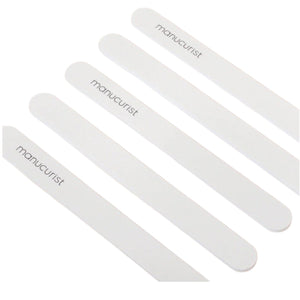 Five MANUCURIST - EMERY BOARD nail files from MANUCURIST INC, each featuring the brand’s logo, are arranged diagonally on a light beige background.