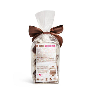 A clear bag of MOUTH PARTY - CHOCOLATE SEA SALT caramels from MOUTH PARTY, tied with a shiny brown ribbon. The label features a pink lips logo and product details.