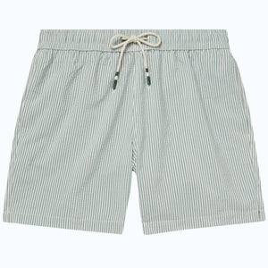 A person wearing HARTFORD - SEERSUCKER SWIM TRUNKS IN GREEN with an elastic waistband and drawstring stands against a plain light background.