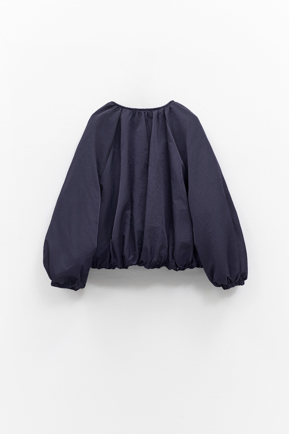 A person models the ELEH NYLON BOMBER JACKET, styled oversized with a matching mini skirt, black ankle boots, and large sunglasses against a plain white background. Brand: ELEH.