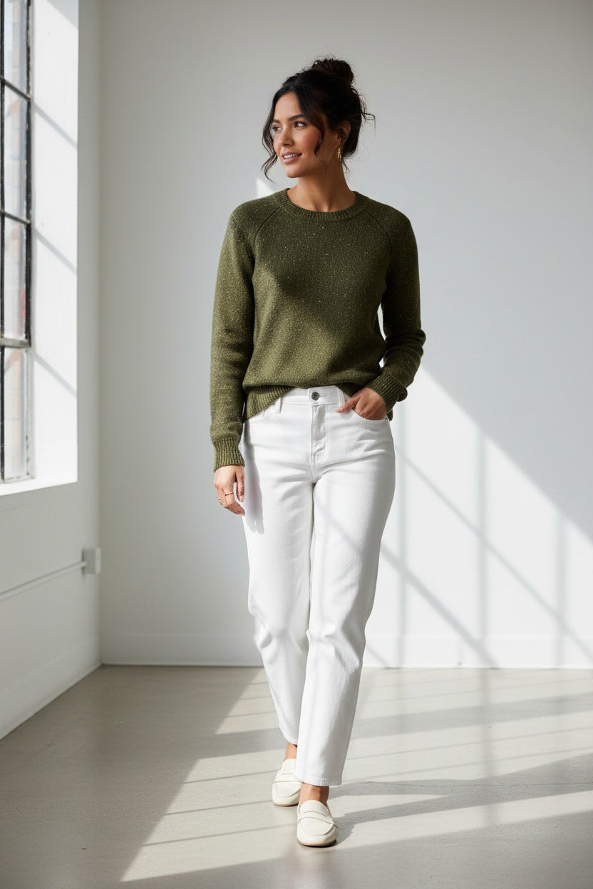 A person wearing the HINSON WU Queenie Long Sleeve Sequin Sweater in Oregano—an everyday essential crafted from breathable cotton with subtle sequin embellishments—paired with gold hoop earrings and touching their collar with one hand.