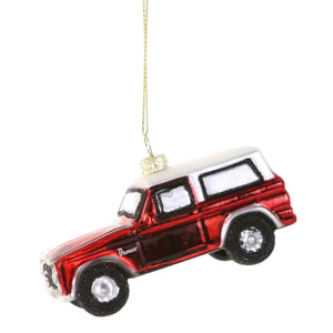 A 4-inch decorative red and white GLASS VINTAGE TRUCK ORNAMENT by Cody Foster, hanging by a gold thread.